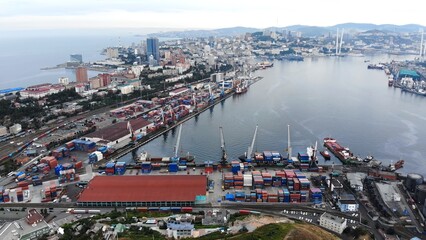Industrial cargo cranes loading colorful containers onto freight ships at vladivostok commercial sea port, a major trade hub in russia © Довидович Михаил
