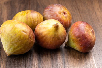 Freshly ripe figs. Healthy Mediterranean fig fruit. Fresh figs on a dark background. Beautiful blue violet figs with leaves, copy space, closeup