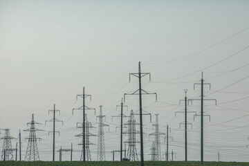High voltage power lines and pylons against blue sky. Electric tower. Power transmission lines. Energy security and clean energy.  