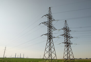 High voltage power lines and pylons against blue sky. Electric tower. Power transmission lines....