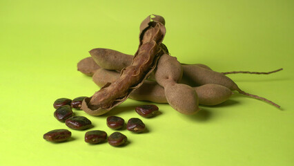 Tamarind fruit with seed isolated on green background with copy space for your text. Top view. Flat lay