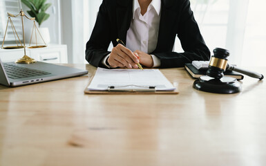 A professional lawyer sits at a desk surrounded by legal books, documents, and a gavel, providing...