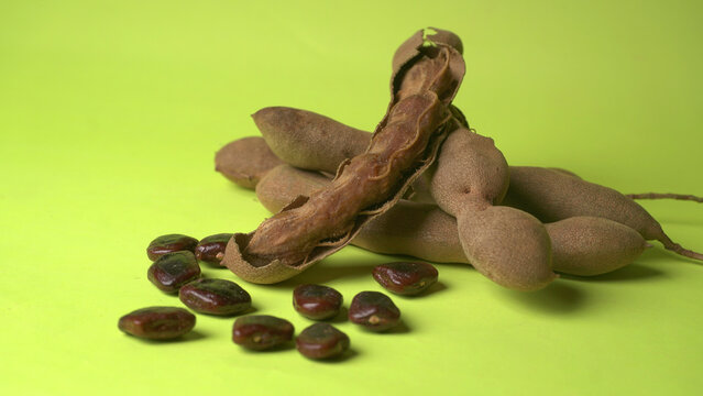 Tamarind fruit with seed isolated on green background with copy space for your text. Top view. Flat lay