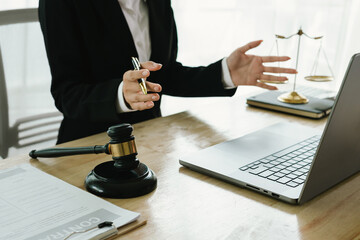 A professional lawyer sits at a desk surrounded by legal books, documents, and a gavel, providing...