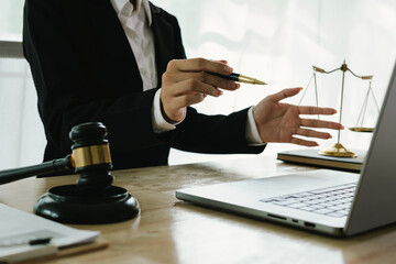 A professional lawyer sits at a desk surrounded by legal books, documents, and a gavel, providing...