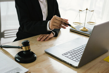 A professional lawyer sits at a desk surrounded by legal books, documents, and a gavel, providing...