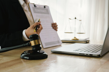 A professional lawyer sits at a desk surrounded by legal books, documents, and a gavel, providing...