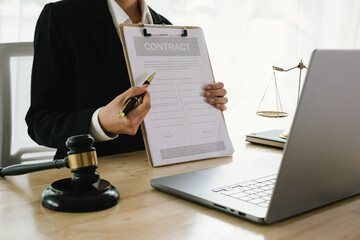 A professional lawyer sits at a desk surrounded by legal books, documents, and a gavel, providing...