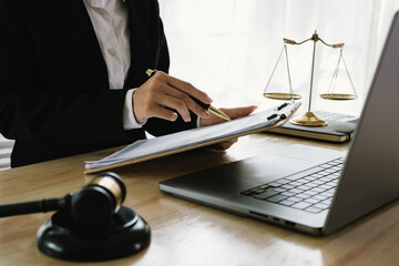 A professional lawyer sits at a desk surrounded by legal books, documents, and a gavel, providing...