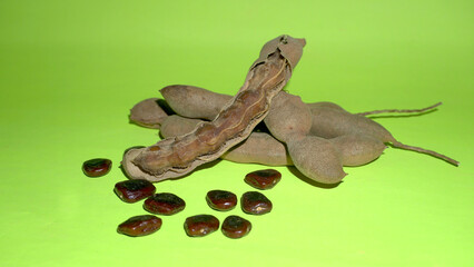 Tamarind fruit with seed isolated on green background with copy space for your text. Top view. Flat lay