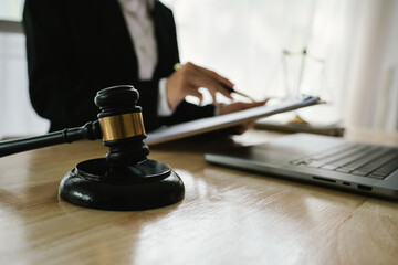 A professional lawyer sits at a desk surrounded by legal books, documents, and a gavel, providing...