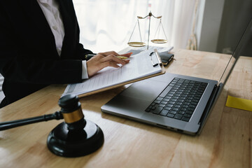 A professional lawyer sits at a desk surrounded by legal books, documents, and a gavel, providing...