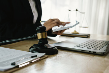 A professional lawyer sits at a desk surrounded by legal books, documents, and a gavel, providing...