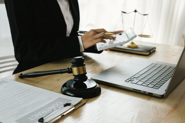 A professional lawyer sits at a desk surrounded by legal books, documents, and a gavel, providing...