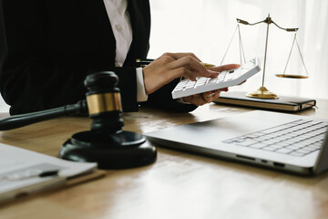 A professional lawyer sits at a desk surrounded by legal books, documents, and a gavel, providing...