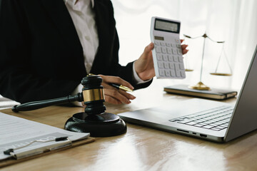 A professional lawyer sits at a desk surrounded by legal books, documents, and a gavel, providing...