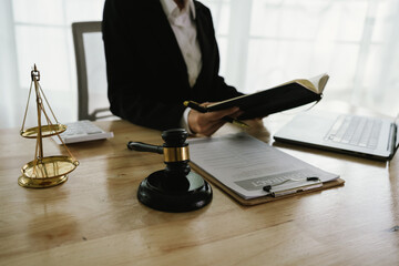 A professional lawyer sits at a desk surrounded by legal books, documents, and a gavel, providing...