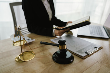 A professional lawyer sits at a desk surrounded by legal books, documents, and a gavel, providing...