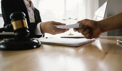 A hand holding stacks of money is shown being exchanged with another hand, implying a transaction,...