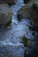 Flowing stream between rocks in a serene natural setting