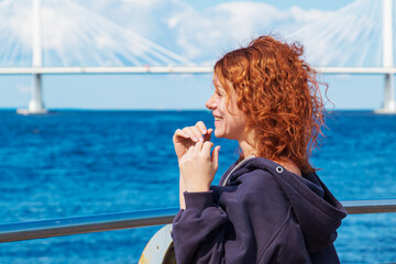Portrait of smiling red-haired curly young woman in sportswear.