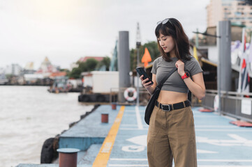 Happy solo southeast asian woman blogger on world travel tourism trip in Thailand. explorer uses...