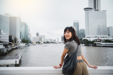 Happy solo southeast asian woman teenager blogger, world travel explorer. Wait for express boat on...