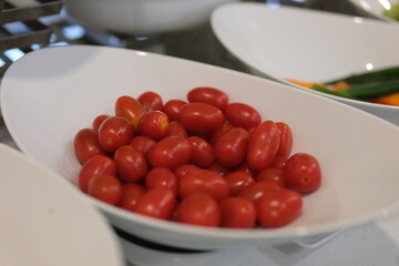 Red cherry tomatoes lie in a box