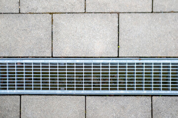 modern drainage grate integrated into a patterned concrete sidewalk, Essential urban infrastructure...
