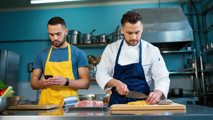 Professional chefs cooking together in modern commercial kitchen while blogger streaming cooking lesson content to social network blog for restaurant service