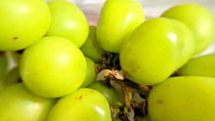 Close-up of fresh Shine Muscat green grapes with smooth skin and natural shine, symbolizing freshness and healthy eating