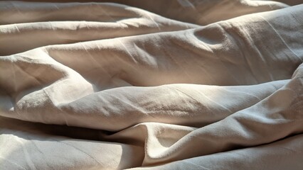 Fototapeta premium Wavy crumpled fabric creating an abstract background pattern