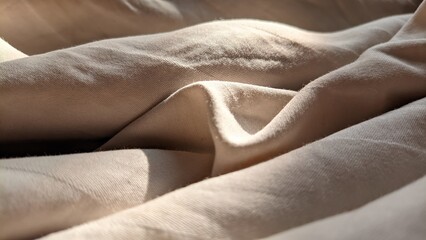 Fototapeta premium Wavy crumpled fabric creating an abstract background pattern