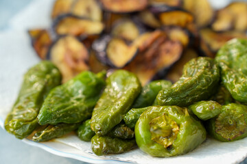 Fried Pimientos de Padron - green pepper-  and eppglants  on a Plate