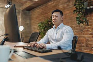 A dedicated and focused professional diligently working on a computer in a stylish and modern...