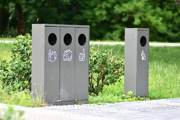 Sorting trash bins in a public park with separate containers for plastic, paper, and glass on the...