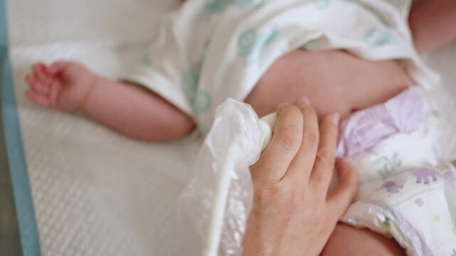 A close-up image showcases a young baby undergoing an abdominal ultrasound examination. A hand gently guides the ultrasound probe. Baby Ultrasound Examination