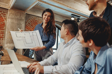 A team discusses architectural plans in a modern workspace, showcasing collaboration and creativity.
