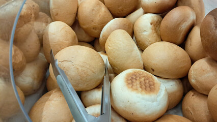 baked bread rolls in a self-service bakery container in supermarket