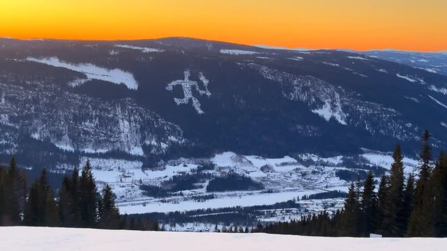 Olympic torch man on top of &Oslash;yer mountain Lillehammer Hafjell Alpine resort Norway Norge chairlift steep groomed trail ski runs golden hour vibrant sunset winter terrain landscape frigid parallax left
