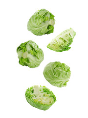 Fresh ripe cabbages falling on white background