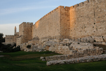Fototapeta premium Golden afternoon sunlight strikes the Tower of David and western expanse of walls and ramparts of the Old City of Jerusalem at twilight.