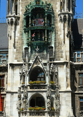 Munich, Marienplatz: detail of the rich gothic architecture of the main tower of the New Town Hall with the statues of the first four Bavarian kings and  the carillon with coopers dancing and knights