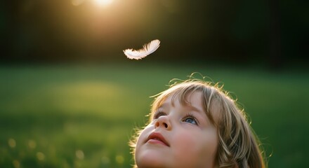 Innocent child gazing up at a delicate white feather floating in golden sunlight