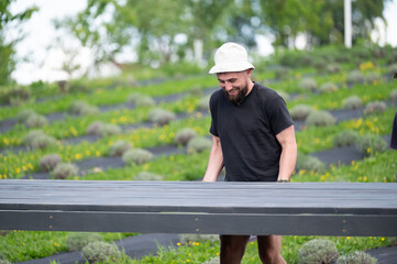 A man helps carry the already assembled floor for the gazebo.