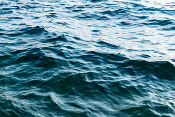 close up sea water surface. minimalist background with water texture in deep blue colors. gentle sea waves. soft liquid pattern