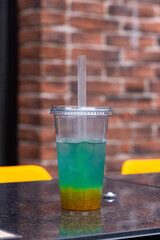 Fresh ice tea or bubble tea with passion fruit, tangerine and juice balls. Drink for summer. Vertical orientation.