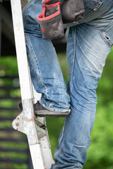 A worker climbs up a ladder while building a gazebo.