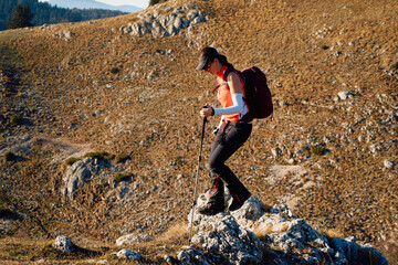 A female mountaineer, equipped with professional gear, enjoys the thrill of her climb as she...