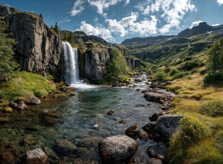 Serene Rocky Landscape with Waterfall and River Flowing Through Lush Green Valley Under Bright Blue Sky with Fluffy White Clouds